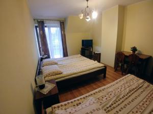 1 dormitorio con 2 camas, mesa y ventana en Willa Pawlikowskich, en Poronin