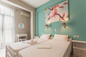 
a bedroom with a bed and a painting on the wall at Protopapas Rooms in Loutro
