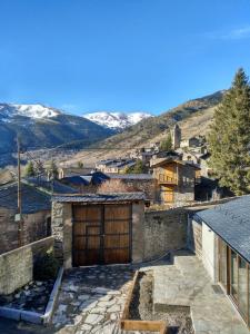 una casa de piedra con un gran garaje de madera en Vilamaroto, en Meranges