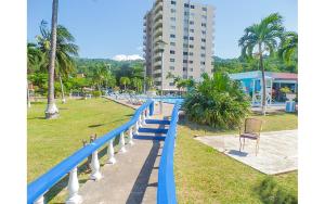 Ein blauer Zaun in einem Park mit einem Gebäude in der Unterkunft Sword Fish Beach Suite@ Turtle Towers in Ocho Rios