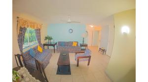 ein Wohnzimmer mit Sofas und einem Tisch in der Unterkunft Sword Fish Beach Suite@ Turtle Towers in Ocho Rios