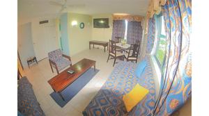 ein Wohnzimmer mit einem Sofa und einem Tisch in der Unterkunft Sword Fish Beach Suite@ Turtle Towers in Ocho Rios