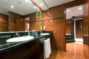 a bathroom with two sinks and a large mirror at Hotel Madrid Alameda Aeropuerto, Affiliated by Meliá in Madrid