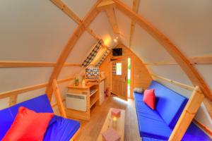 ein Zimmer mit blauer Couch in einem winzigen Haus in der Unterkunft LOCH TAY HIGHLAND LODGES and GLAMPING PARK in Morenish