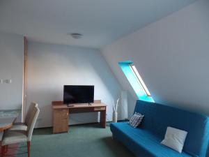 un soggiorno con un divano blu e una televisione di Apartamenty Twoje Mikołajki a Mikołajki