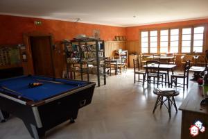 a room with a pool table and tables and chairs at Hôtel de Valdeblore in Valdeblore