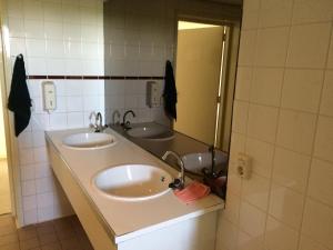 a bathroom with two sinks and a mirror at Waterhut 1 Aduarderzijl in Aduarderzijl