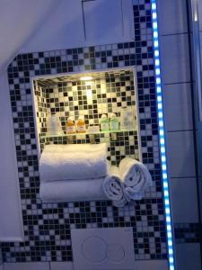a bathroom with a mirror and towels on a tiled wall at Rheinhotel Lilie in Boppard