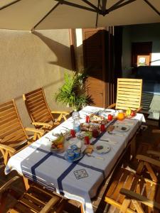 a table with plates of food on it with an umbrella at b&b Caravella in Mezzojuso