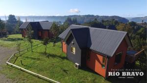 an aerial view of two cottages on a hill at Parque Natural Rio Bravo Lodge in Castro