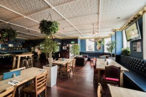 un ristorante con tavoli e sedie in legno e pareti blu di Albion Hotel ad Auckland