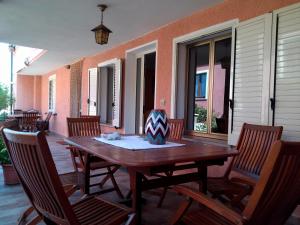 Une table et des chaises en bois sont disponibles sur la terrasse. dans l'établissement Corte Mannoni, à Porto Pozzo