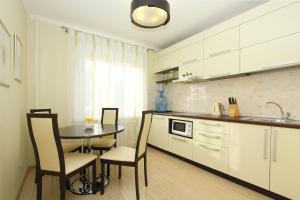 チェリャビンスクにあるAlt-Otel Apartmentsのキッチン(テーブル、椅子、シンク付)