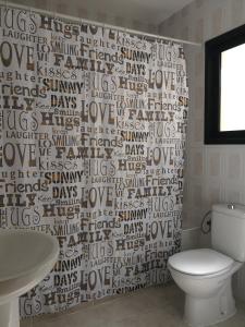 La salle de bains est pourvue de toilettes blanches et d'un rideau de douche. dans l'établissement Calle Eusebio Carballo Estévez, à Corralejo 15 autres photos