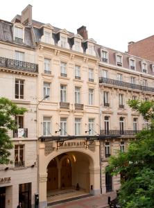 een groot gebouw met een boog ervoor bij Marivaux Hotel in Brussel