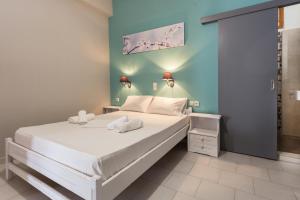 
a bedroom with a white bed and white walls at Protopapas Rooms in Loutro
