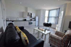 a living room with a couch and a table at Dwell Living - Mowbray in Sunderland