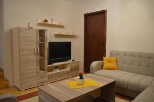 a living room with a couch and a television at Etno Restoran Ranc in Radibuš
