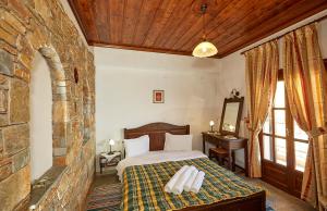 a bedroom with a bed and a stone wall at Hotel Atrapos in Kissos