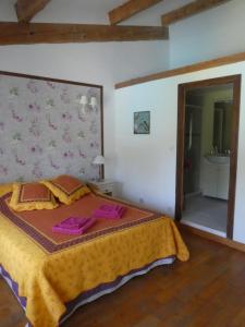 sypialnia z łóżkiem z żółtym kocem i lustrem w obiekcie Gîte Eloi Merle w mieście Olonzac