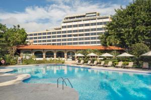 un hotel con una gran piscina frente a un edificio en El Embajador, a Royal Hideaway Hotel, en Santo Domingo