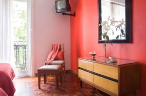 a bedroom with red walls and a dresser and a chair at Petit Recoleta Suites in Buenos Aires