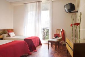 a hotel room with two beds and a window at Petit Recoleta Suites in Buenos Aires