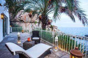 een patio met stoelen en uitzicht op de oceaan bij Arbatax Park Resort - Suites Del Mare in Àrbatax