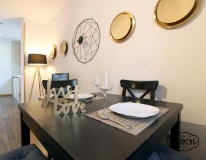 a dining room table with a plate and two chairs at Huertas Apartment - Estancias temporales in Madrid