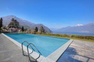 a swimming pool with a view of the mountains at Sant’Andrea Penthouse in Menaggio