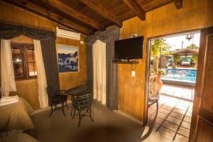 a room with a bed and a television and a table at Hosteria del Prado in Salta