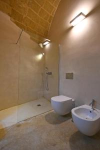 a bathroom with a shower and a toilet and a sink at I Bastioni San Domenico - Boutique Hotel in Gallipoli