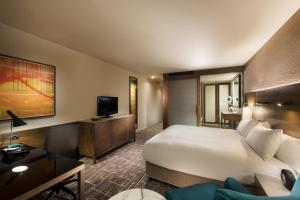 
a hotel room with two beds and a television at Pan Pacific Melbourne in Melbourne
