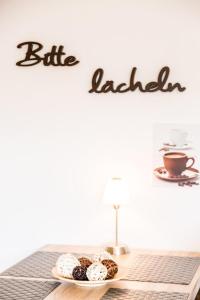 een bord donuts op een tafel met een bord dat bijtleider leest bij Petra in Goslar