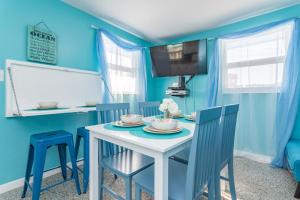 uma sala de jantar azul com uma mesa branca e cadeiras em Villa Paradise, Pet Friendly em Panama City Beach