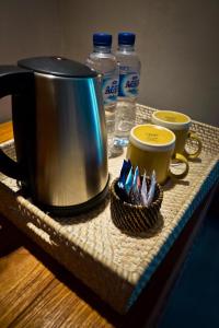 a tray with two coffee cups and a tea kettle at Umadewi Surf & Retreat in Pulukan