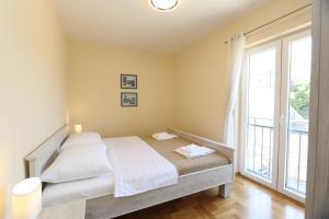 1 dormitorio con cama y ventana grande en Apartment Soline Cove, en Soline