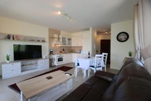 sala de estar con sofá y cocina con mesa en Apartment Soline Cove, en Soline