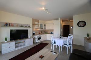 cocina con mesa con sillas y TV en Apartment Soline Cove, en Soline