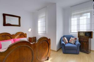 a bedroom with a bed and a blue chair at Casa Surida in Štinjan