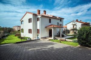 uma grande casa branca com uma entrada em Apartment Falu em Štinjan
