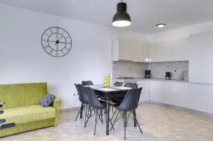 a kitchen and a dining room with a table and chairs at Apartment Falu in Štinjan