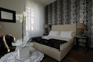 a bedroom with a bed with a black and white wallpaper at Luxury B&B La Dimora Degli Angeli in Florence