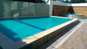 a swimming pool with blue water and a fence at APARTAMENTO CENTRICO, CÓMODO y DE LUJO in Santa Cruz de la Sierra