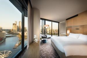 a hotel room with a bed and a window at Pan Pacific Melbourne in Melbourne
