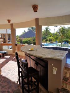 a kitchen with a bar with a view of a pool at Luxury apartment with ocean view at the beach in Cabarete