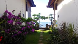 einen Weg, der zu einem Haus mit Meerblick führt in der Unterkunft Tambun Sari Beach Homestay in Amed