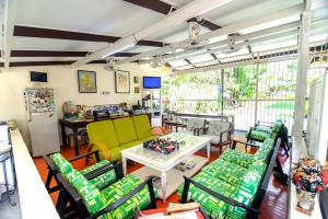 a living room with green chairs and a table at Casugria Dutch Residence 1810 in Malacca