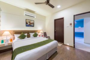a bedroom with a large bed and a sliding glass door at Treebo Trend Nestlay Casa in Chennai