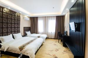 a hotel room with two beds and a desk at Zolotoe Vremya Hotel in Khabarovsk